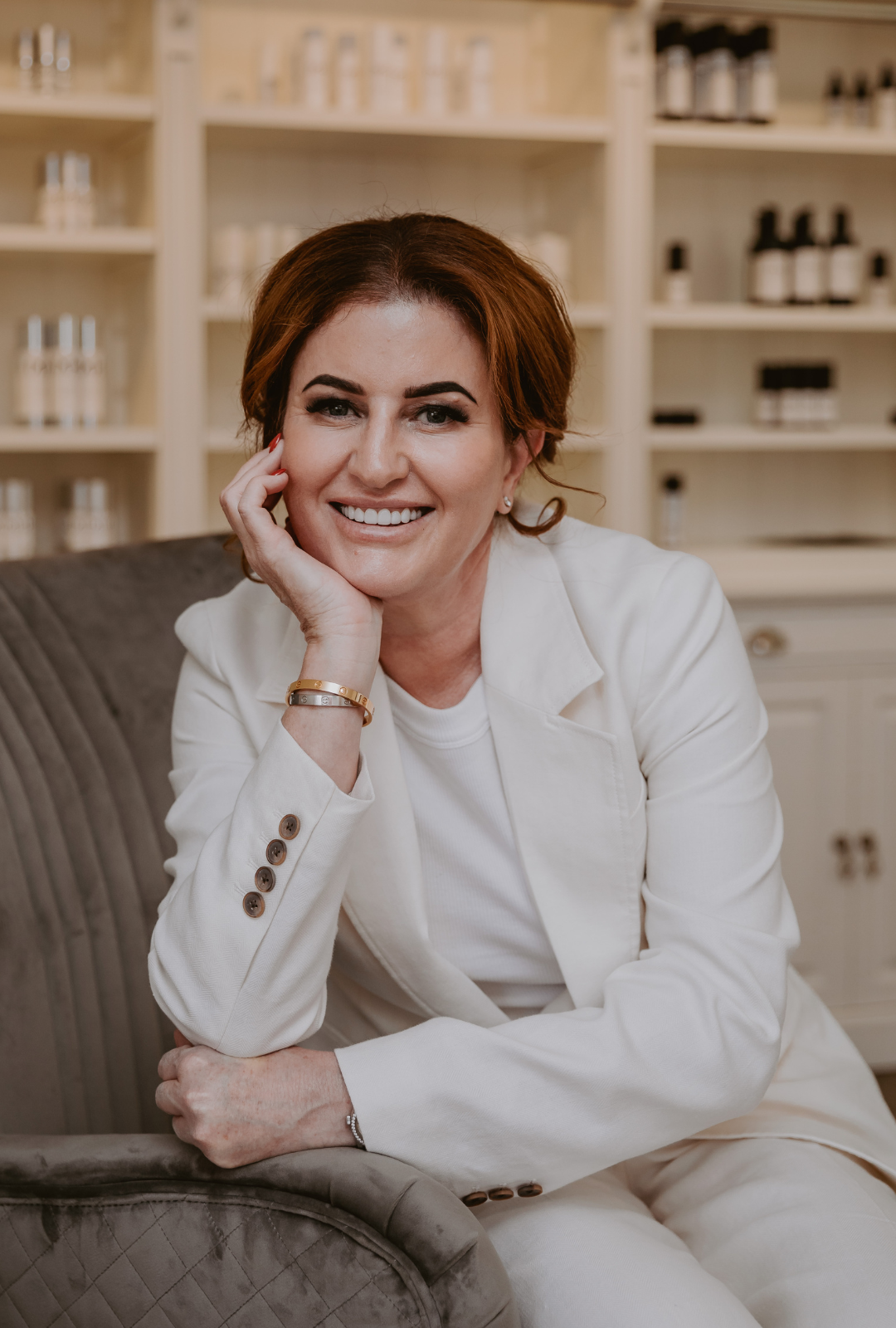 Mel Hornery, owner of Mel Hornery Cosmetics, sitting in front of her skin care range, showcasing her dedication to skincare and beauty.