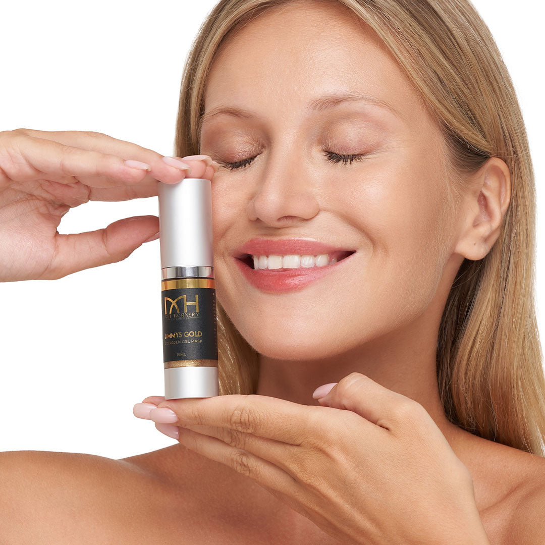 Model with clear skin holding Jimmys gold Serum, a premium skincare product by Mel Hornery Cosmetics.