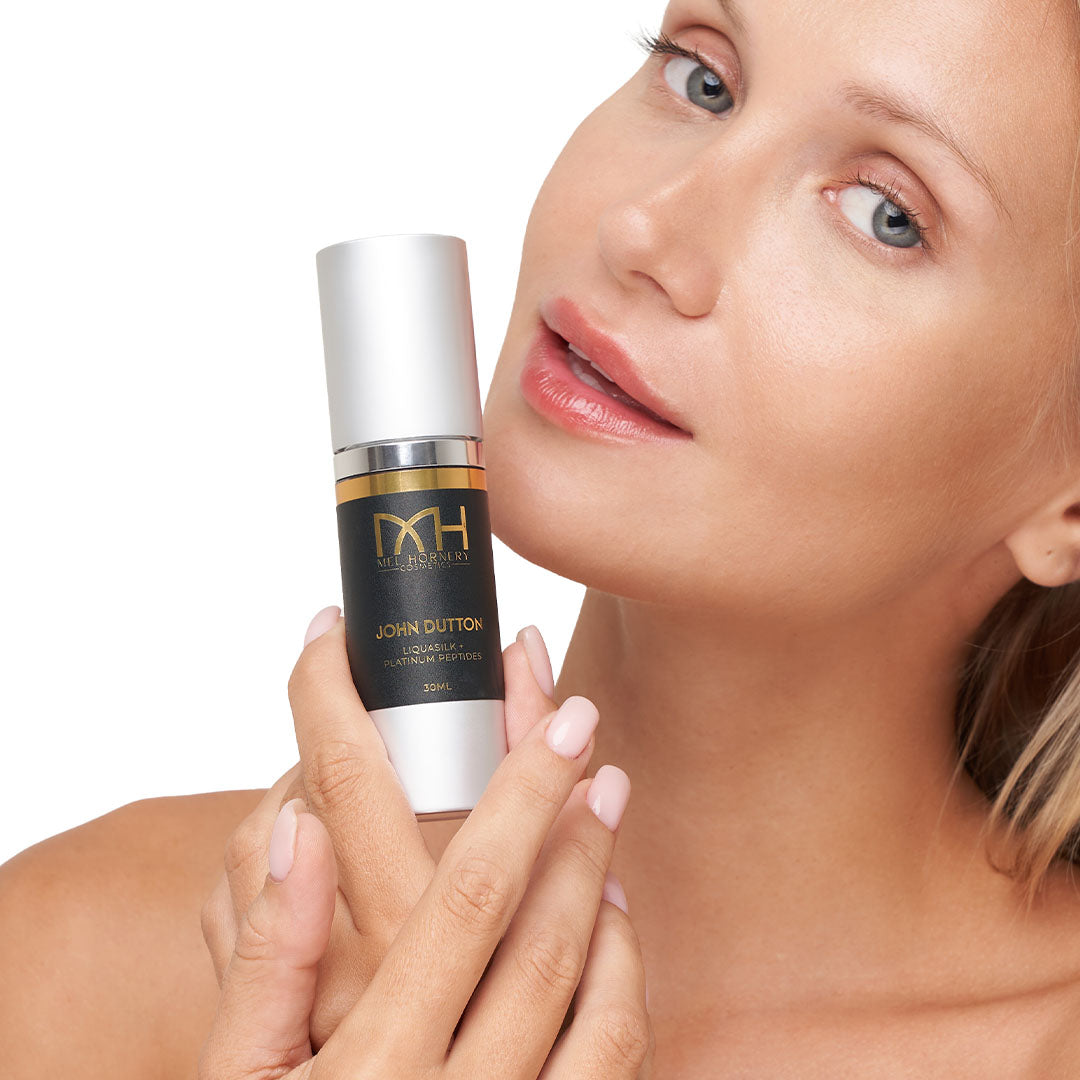 Model with clear skin holding John Dutton Serum, a premium skincare product by Mel Hornery Cosmetics.