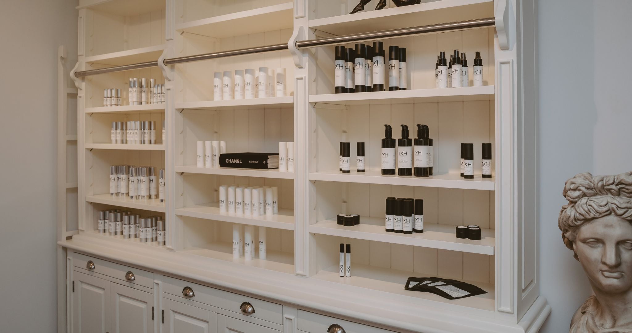 Mel Hornery Cosmetics wall of skincare products at their skin care clinic, featuring a diverse range of lotions, serums, and treatments arranged neatly on elegant shelves.