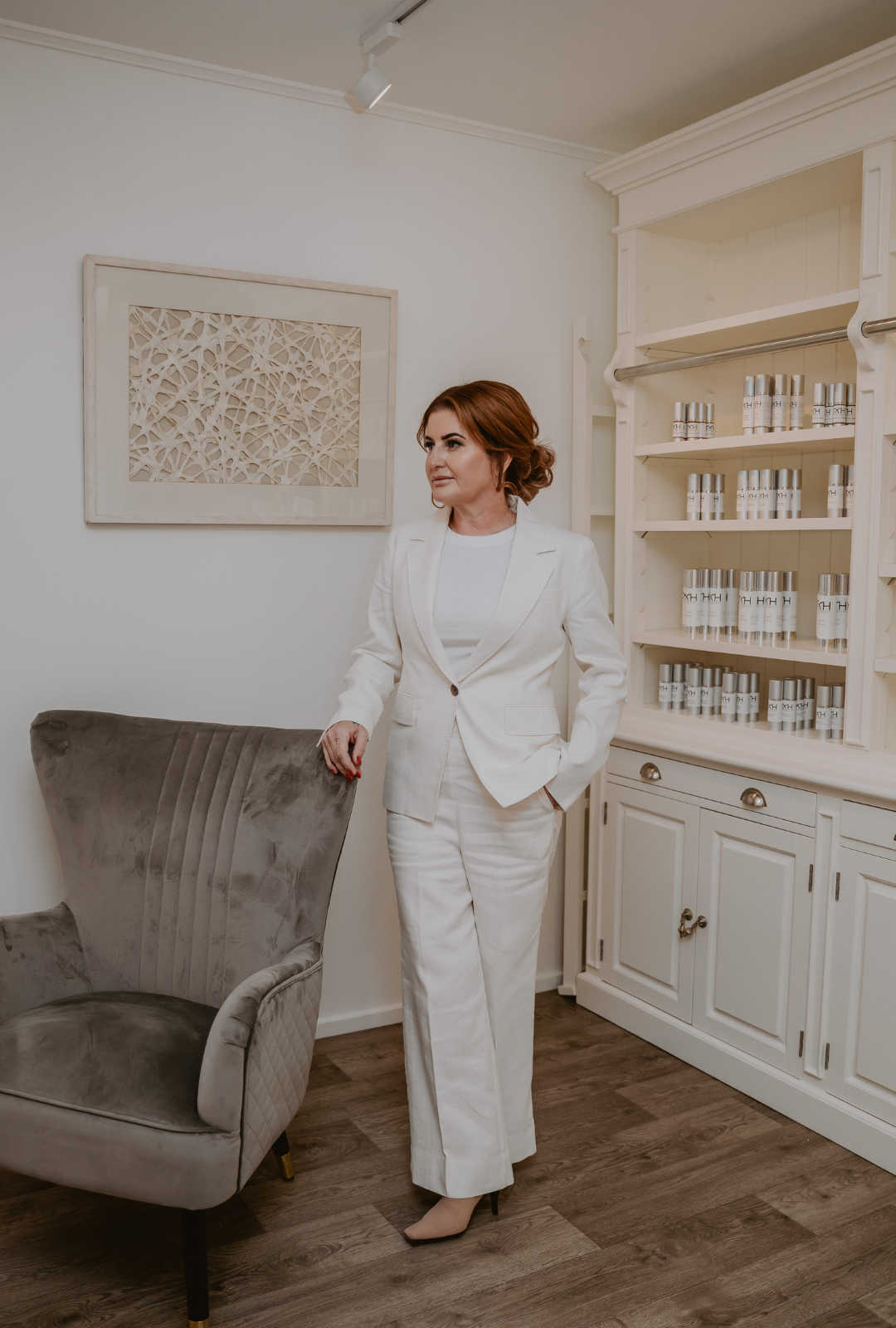 "Mel Hornery, owner of Mel Hornery Cosmetics, standing in front of her skin clinics skincare range, showcasing her dedication to skincare and beauty."