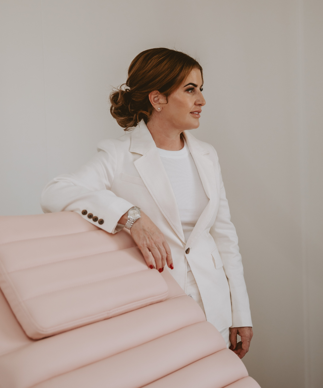 Mel Hornery, founder of Mel Hornery Cosmetics, standing confidently next to a patient chair at one of her renowned skin clinics.